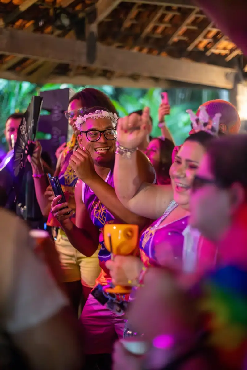 Grupo dançando de copo na mão em festa à noite